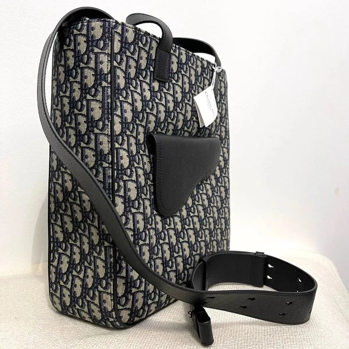Side/profile view — Dior Men's Saddle Tote Bag in beige and black Dior Oblique jacquard with black grained calfskin saddle pocket